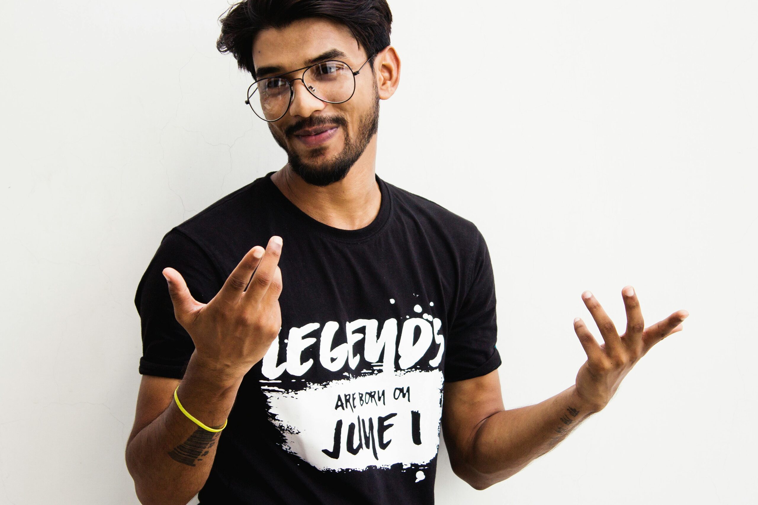 South Asian man wearing eyeglasses and a printed t-shirt posing casually in Varanasi, India.